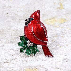 Red cardinal pin brooch with green leaves and crystals and green crystal eye